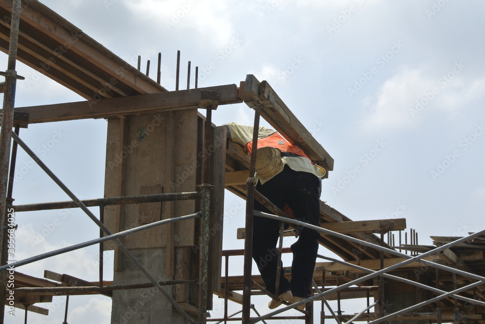 
MALACCA, MALAYSIA -JULY 12, 2016: Construction workers fabricating timber formwork at the construction site in Malacca, Malaysia. The formwork was mainly made from timber and plywood. 