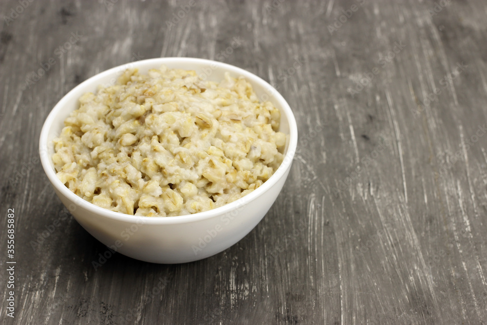 Bowl of oats porridge on a gray background. Healthy breakfast Bowl of oats porridge on a gray background. Healthy breakfast