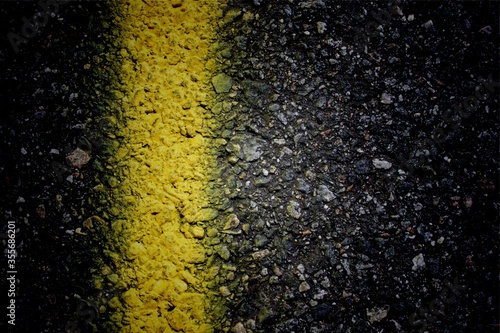 A closeup view of the yellow marking on a asphalt road.