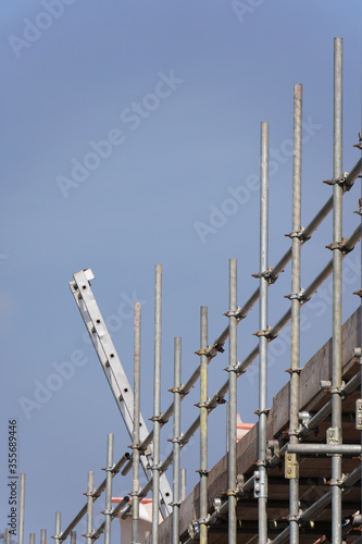 Scaffolding and ladder on a housing building site against a blue sky
