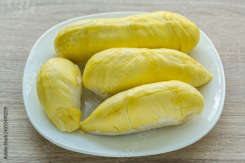 Fresh durian fruit placed on a white plate. Durian the king of fruits The yellow color is on the white plate. Ripe durian tropical fruit summer for sweet dessert or snack in Thailand 