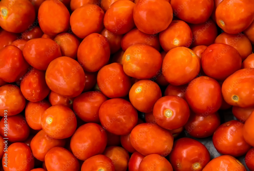 A pile of tomatoes. Summer tray market agriculture farm full of organic tomatoes. Fresh tomatoes.use for background or wallpaper. Delicious red tomatoes. selective focus.