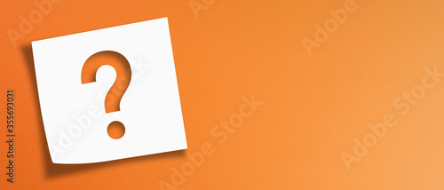 Note paper with question mark on panoramic orange background	
