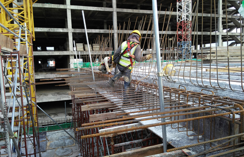 MALACCA, MALAYSIA -SEPTEMBER 23, 2016: Construction workers fabricating steel reinforcement bar at the construction site in Malacca, Malaysia. The reinforcement bar was tied together using tiny wire. 