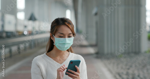 Woman wear medical mask and use of mobile phone at outdoor