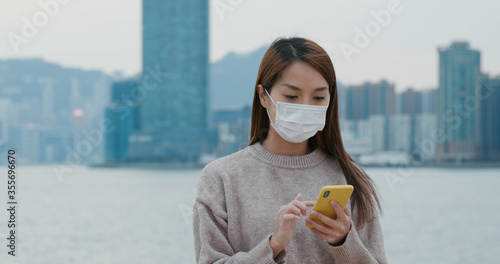 Canvas Print Woman wear medical mask and use of mobile phone at outdoor