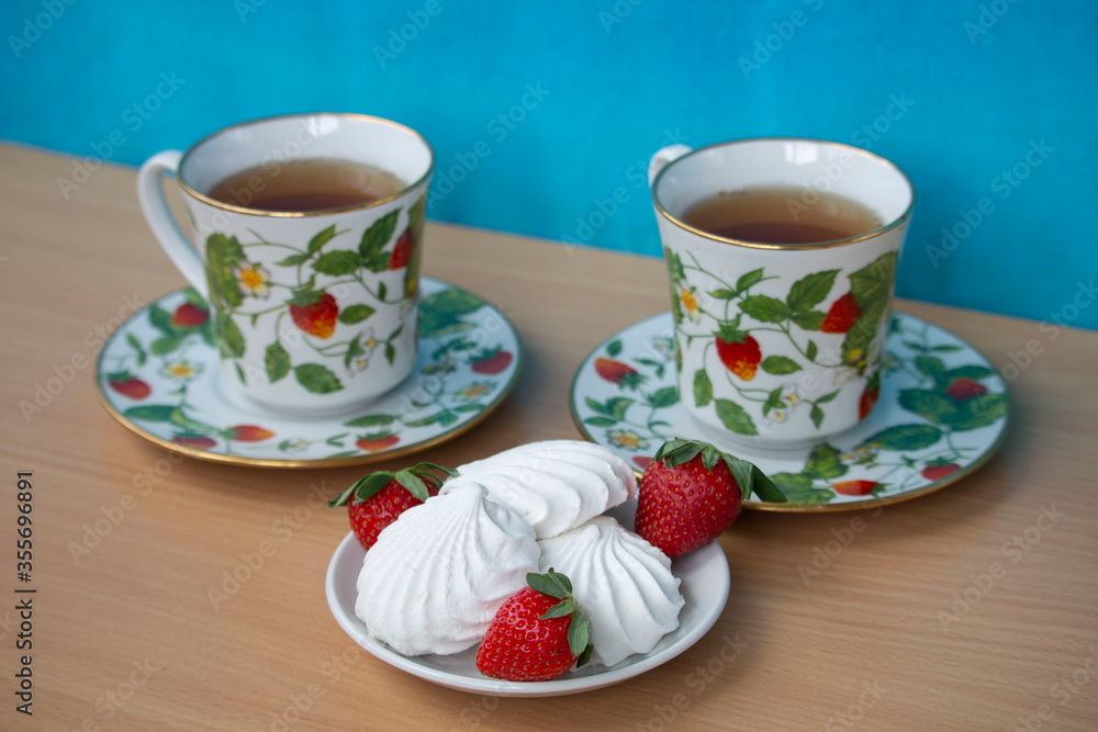 two cups of tea and marshmallow with strawberries two cups of tea and marshmallow with strawberries