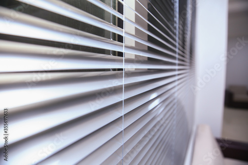 Office blinds. Modern wooden jalousie. Office meeting room lighting range control. venetian blinds by the window . Sunlight coming through venetian blinds by the window .