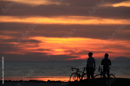 father and son on the beach at sunrise