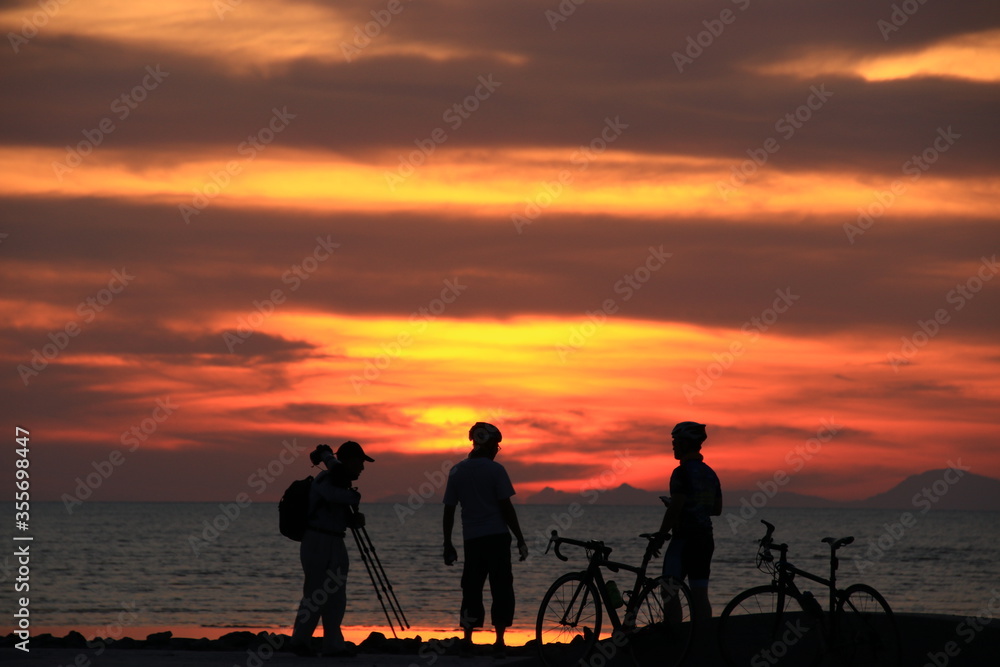 silhouette of a couple on a bike at sunrise