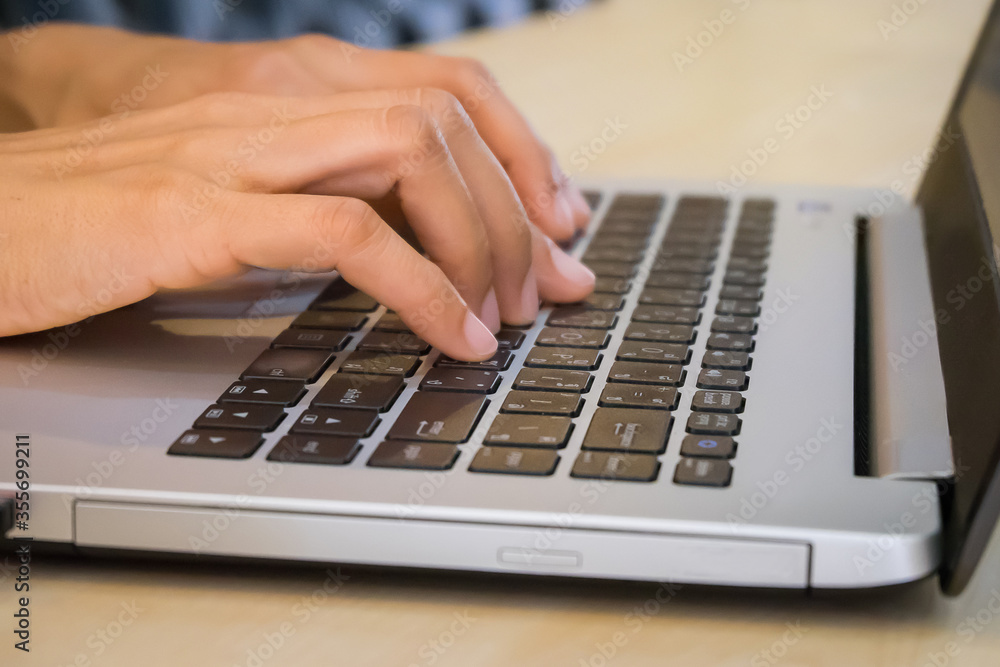 Female office worker typing on the keyboard close up.Woman using laptop in cafe close up.Young business woman working on her laptop.