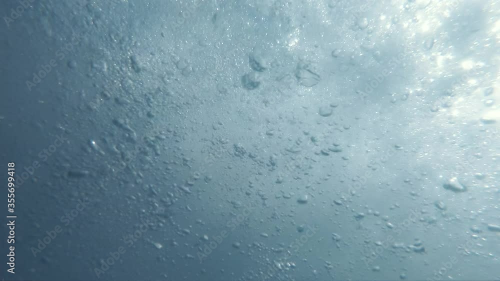 Underwater Bubbles with sunlight through water surface, natural slow motion underwater scene Underwater Bubbles with sunlight through water surface, natural slow motion underwater scene