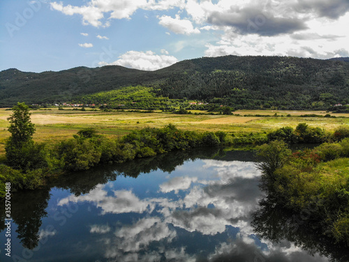 View of the Lika River in small village Donji Kosinj in Croatia. Water reflection of clouds. © Vedrana