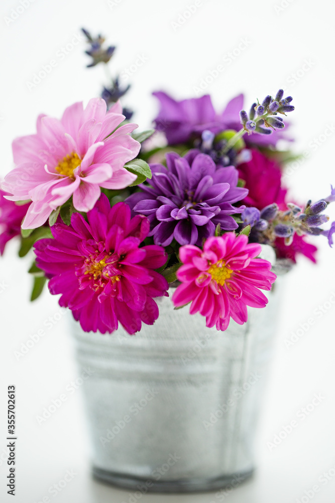 Bouquet of asters in small bucket 
