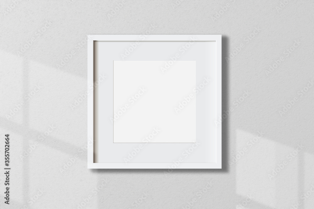 © Idol Design - Minimal empty square white frame picture mock up hanging on white wall background with window light and shadow. isolate image