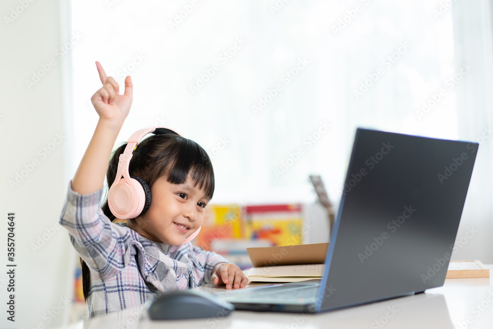 Attractive asian schoolgirl is enjoy greeting to friend and teacher before start online lesson at home, social distance during quarantine, self-isolation, online education concept, homeschooling. Attractive asian schoolgirl is enjoy greeting to friend and teacher before start online lesson at home, social distance during quarantine, self-isolation, online education concept, homeschooling.