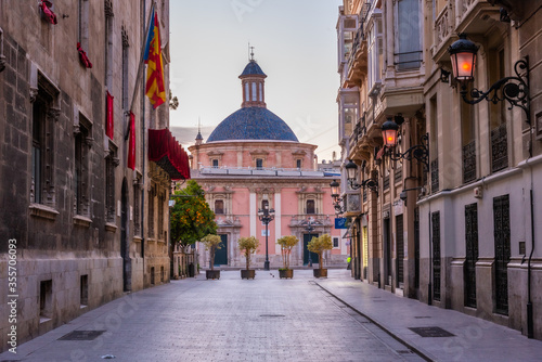 Sunrise view of Basilica de la Virgen de los Desamparados through a narrow street in Valencia, Spain photo