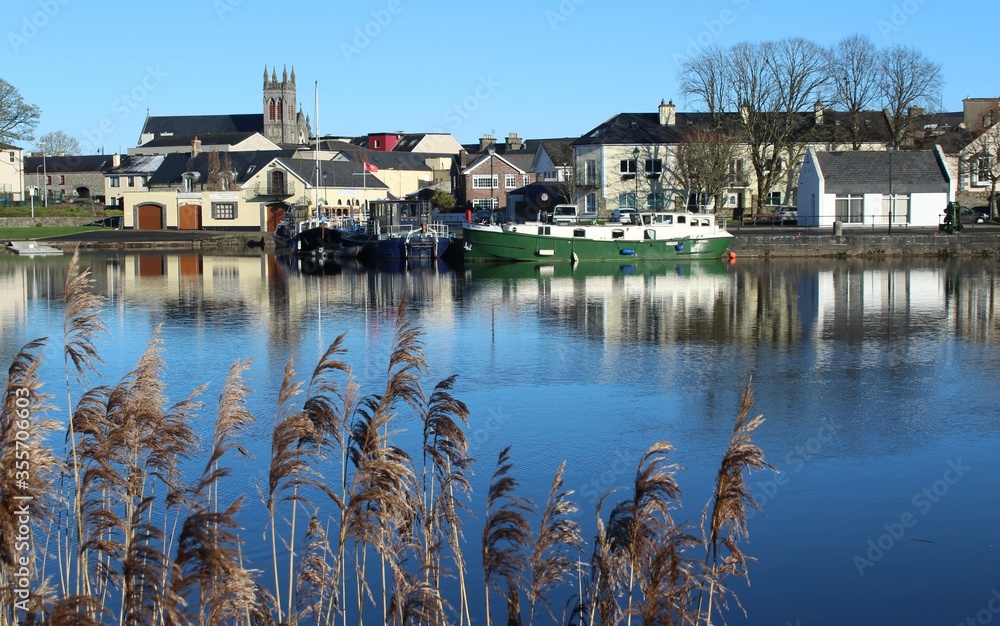 Carrick-on-Shannon, County Leitrim, Ireland viewed from across River Shannon against backdrop of blue sky on winter day