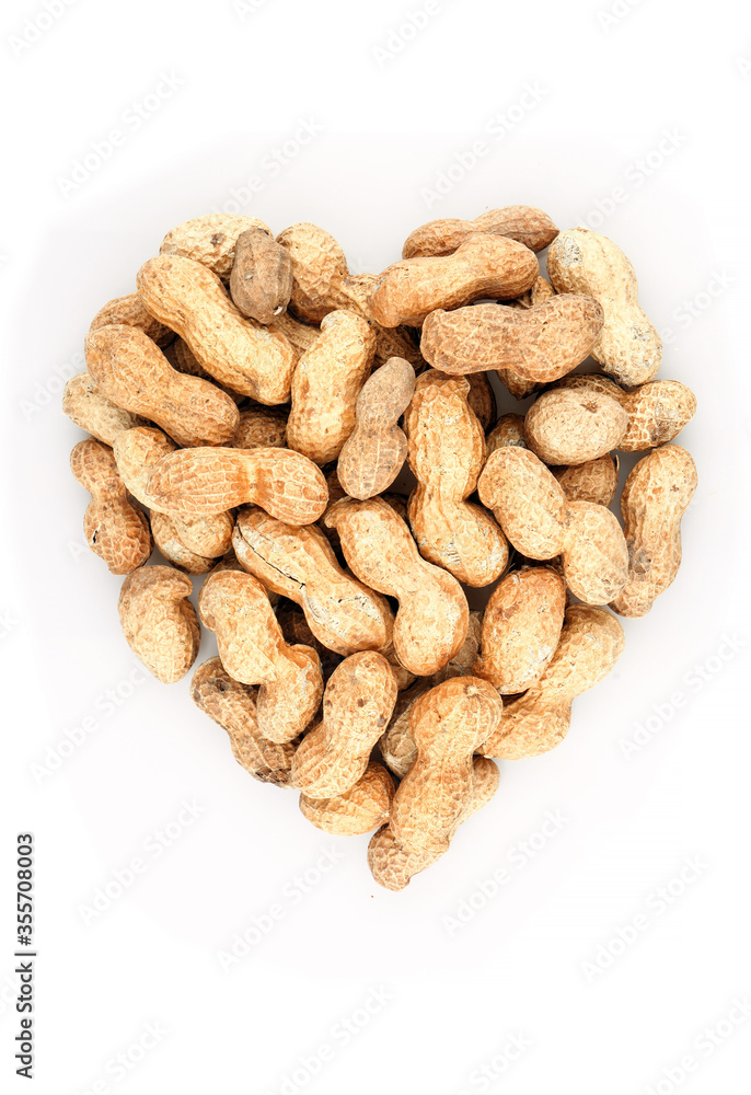 Heart shaped organic In shell peanuts heap on white background Heart shaped organic In shell peanuts heap on white background