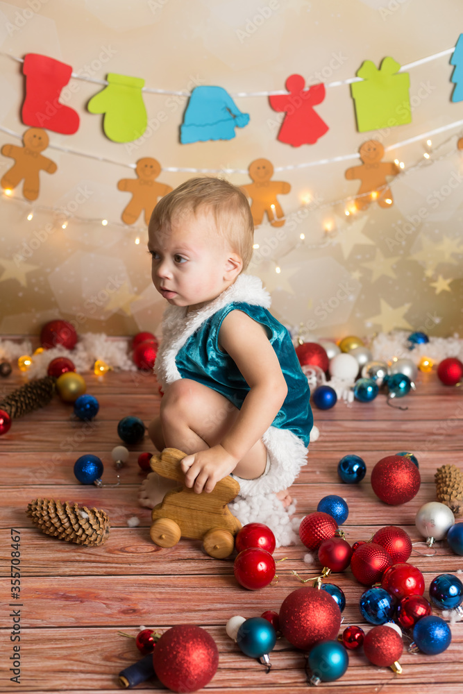 Obraz premium a boy in a Christmas costume plays with a wooden toy