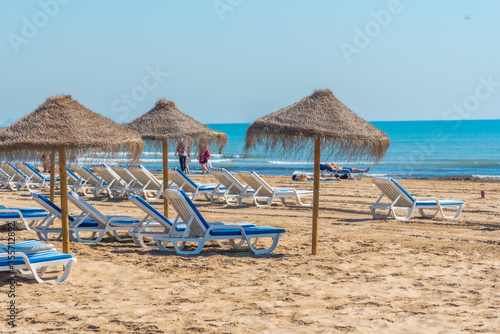 Sunbeds and umbrellas on a beach in Valencia, Spain photo