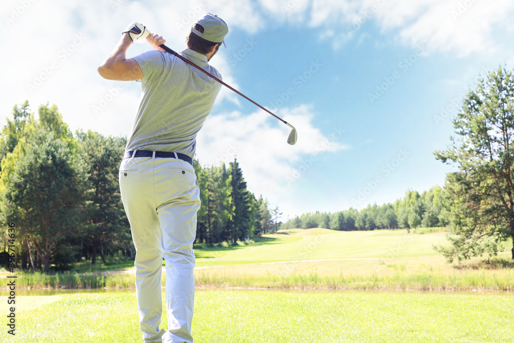 Golfer hits an fairway shot towards the club house. Golfer hits an fairway shot towards the club house.