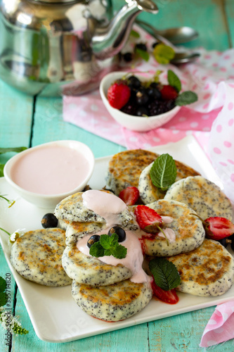 Summer breakfast. Homemade cottage cheese pancakes with poppy seeds, sour cream sauce with strawberries.