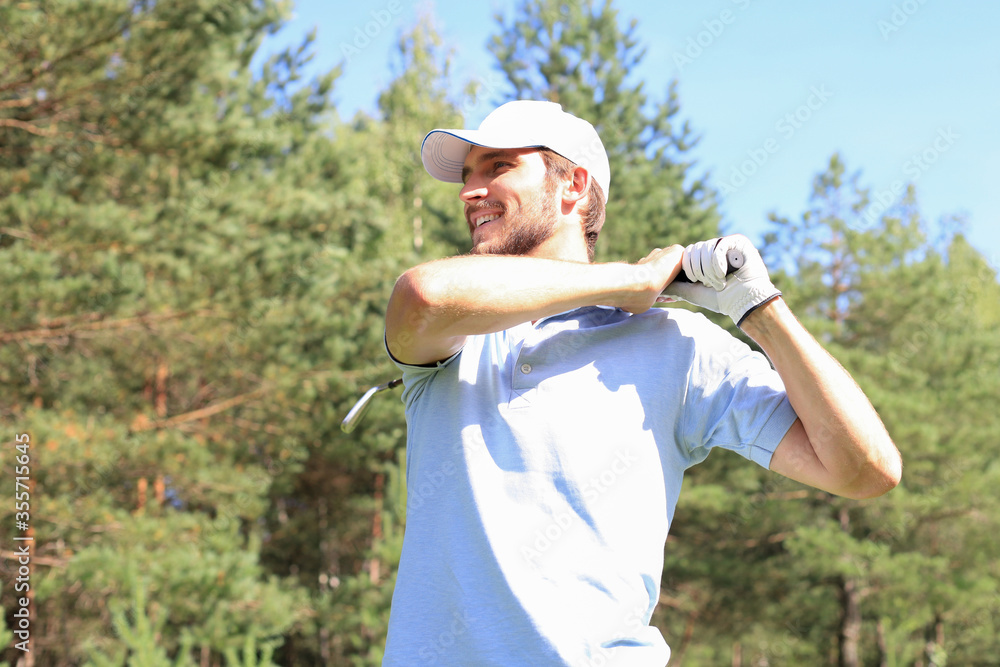 Golfer hitting golf shot with club on course while on summer vacation. Golfer hitting golf shot with club on course while on summer vacation.