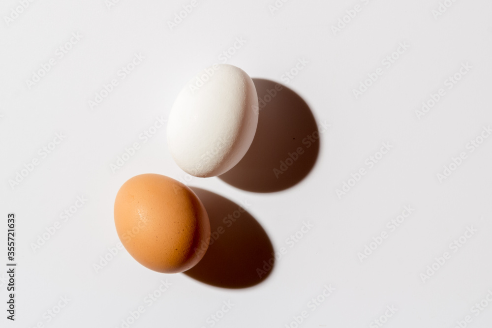 Two white eggs lie on a White background Two white eggs lie on a White background