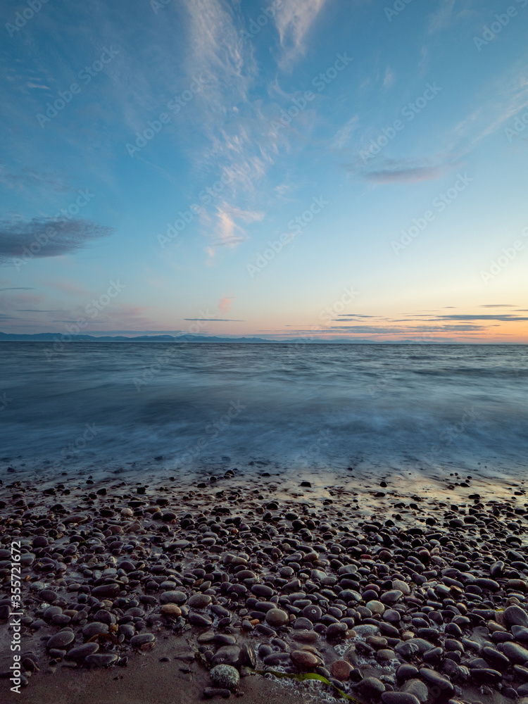 Pebbles along beach with waves and amazing sky. Pebbles along beach with waves and amazing sky.