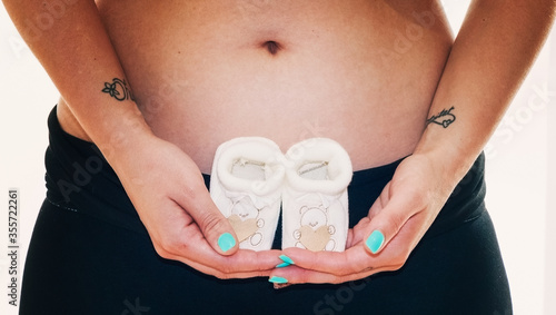 Small shoes for the fetus in the belly of the pregnant woman © aleiximg