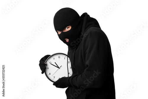 Fototapeta Portrait of masked thief with clock isolated over white wall