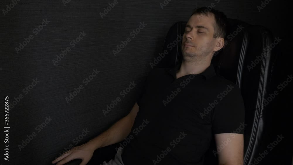 Young Man Lying, Relax and Enjoying in Black Massage Chair in the Lounge Area in Airport Young Man Lying, Relax and Enjoying in Black Massage Chair in the Lounge Area in Airport