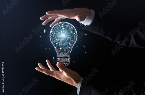 New ideas with innovation and creativity. Man hands do trick and glowing abstract light bulb appears