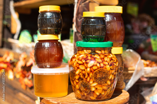 on the exotic market, honey with nuts and figs is sold in jars. light dark golden. bazaar