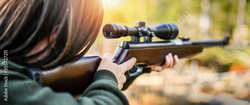 Shooter is on the hunting. Hunt prey rifle. Woman aiming on animals with gun