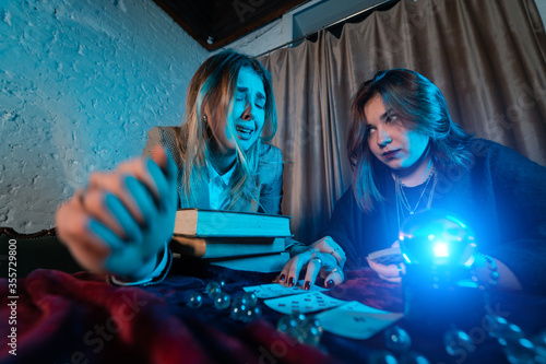 Fortune teller forecasting the future to woman with cards photo