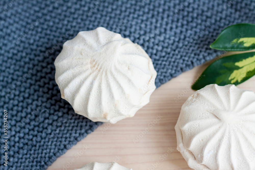 Marshmallows. Vanilla sweet homemade marshmallows. Light composition with green natural leaf and plaid. Violet flower. Sweet delicious dessert. Marshmallows. Vanilla sweet homemade marshmallows. Light composition with green natural leaf and plaid. Violet flower. Sweet delicious dessert.