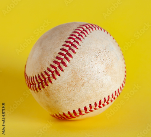 worn baseball isolated on yellow background, team sport