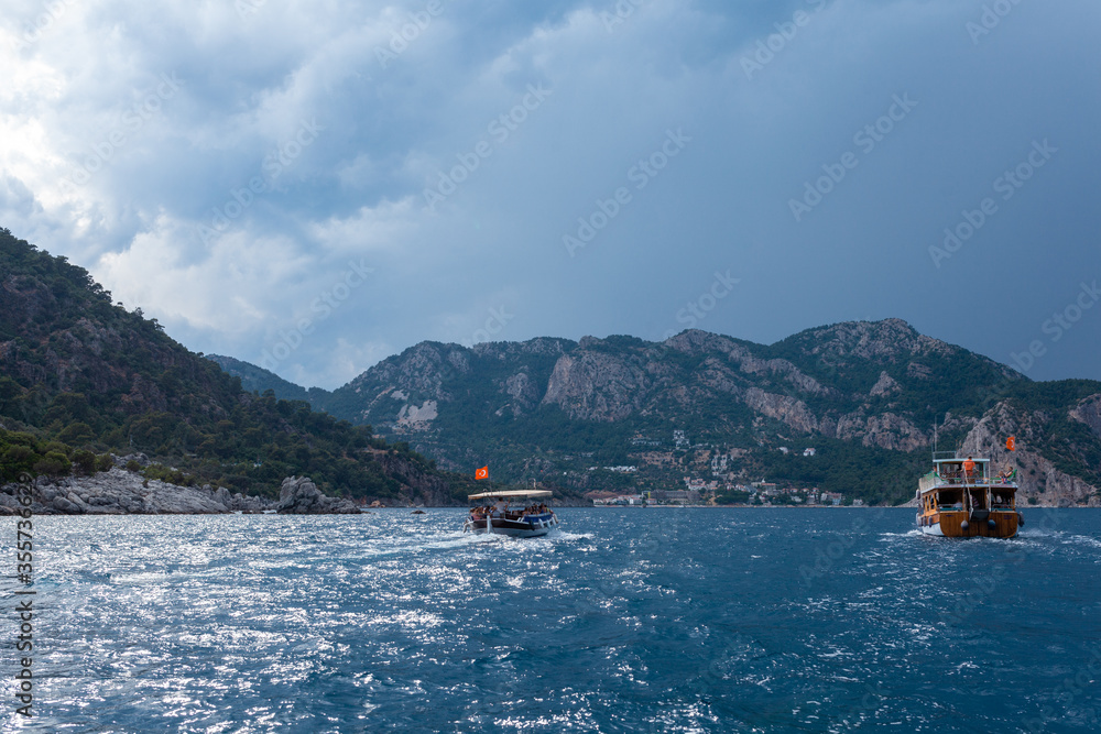View from the bow of a sea boat on sea boats, mountains and stormy sky