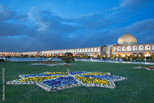 Illuminated Sheikh Lotfollah Mosque and Naqshe Jahan Square of Isfahan against Blue Sky Before Night photo