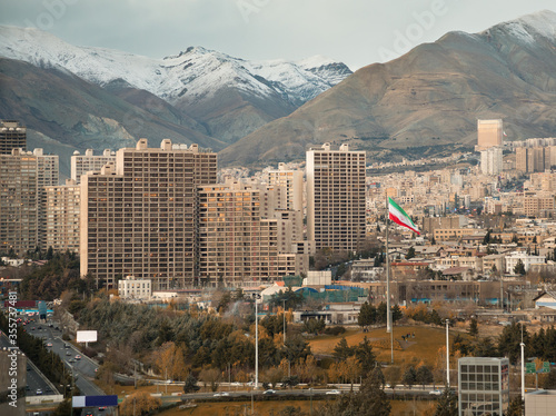 Large Iran Flag and Tehran City Skyline against Alborz Mountains with Instagram Warm Effect