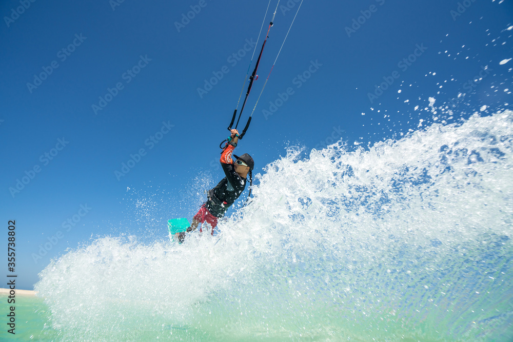 kiter does a difficult trick on a background of transparent water and blue sky kiter does a difficult trick on a background of transparent water and blue sky