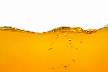 Closeup process of splashing of green tea. Macro shot of liquid in transparent glass. Abstract background with splashes, sprays, waves, bubbles of lager beer, whiskey, cognac, rum, brandy.
