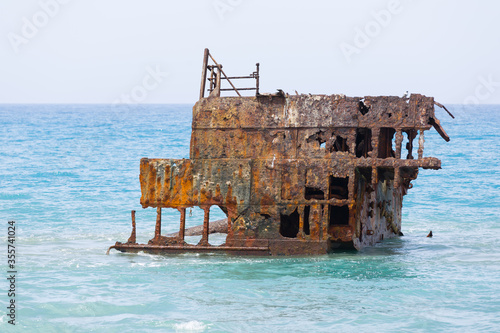 Fototapeta Rusty ship wreck remains surrounded by water near to Cyprus shores