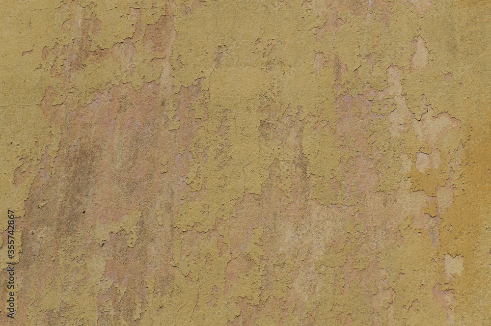 Full frame image of the yellow stucco wall with old weathered paint. Old plaster shabby surface for texture or background, design concept, copy space