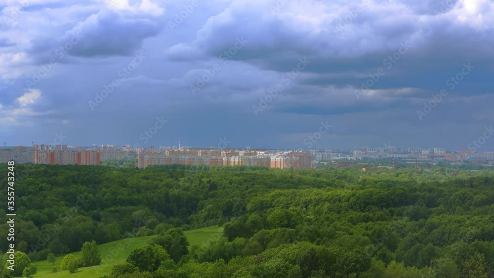 4K Video, Timelapse. View from a balcony to a deserted park during the quarantine period associated with the COVID-19 epidemic. Changeable weather in the summer city. Quick change of clouds in the sky 4K Video, Timelapse. View from a balcony to a deserted park during the quarantine period associated with the COVID-19 epidemic. Changeable weather in the summer city. Quick change of clouds in the sky