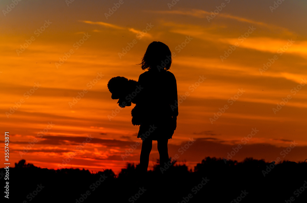 a child looks at the sunset
