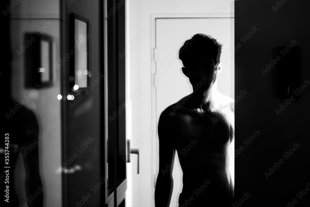 Black and white light shadows silhouette shirtless teenager curly hair