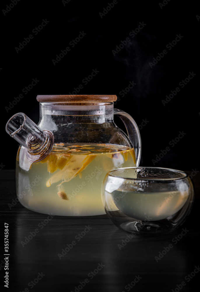 tea pot and Cup of ginger tea with honey and lemon on black background tea pot and Cup of ginger tea with honey and lemon on black background